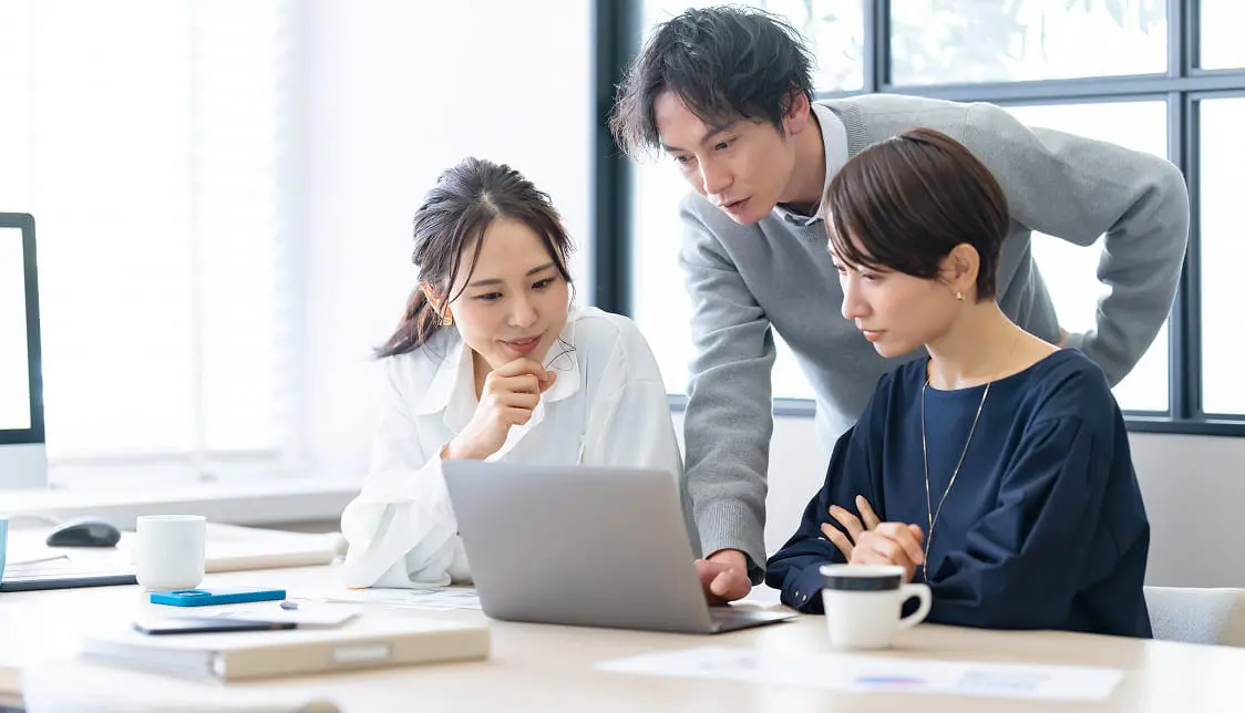 女性2人と男性1人が真剣に画面を見ながら議論をしている様子